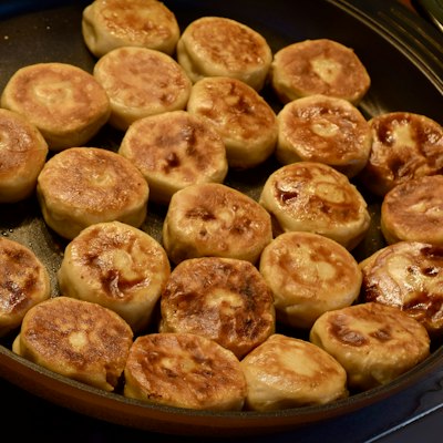 Pan-fried buns browning in a skillet